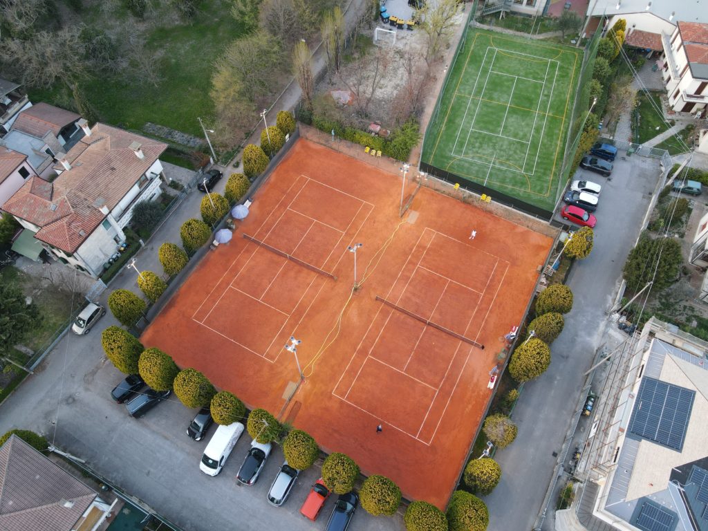 Foto aerea dei campi da tennis in terra rossa e del campo in erba sintetica
